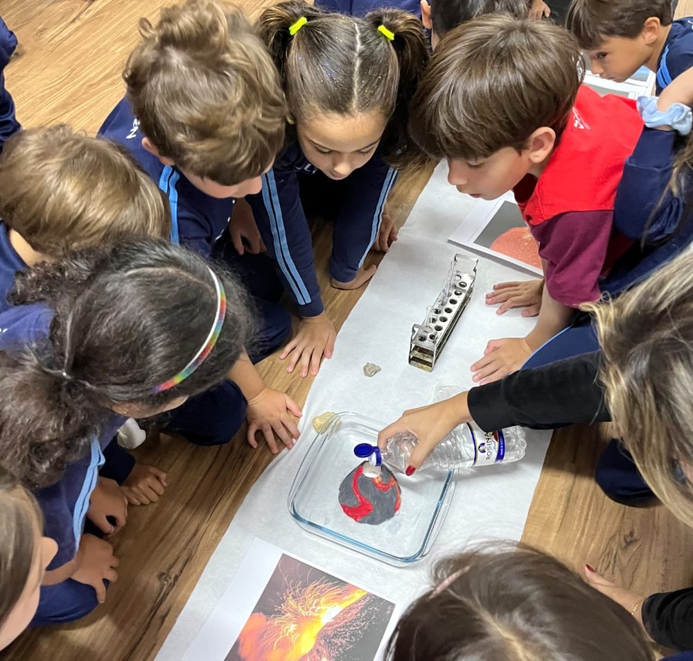 Alunos observando experimento em grupo